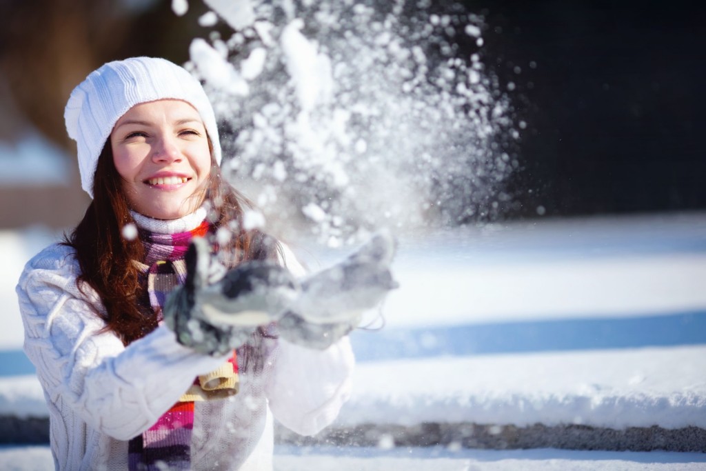 Jeune femme qui lance de la neige