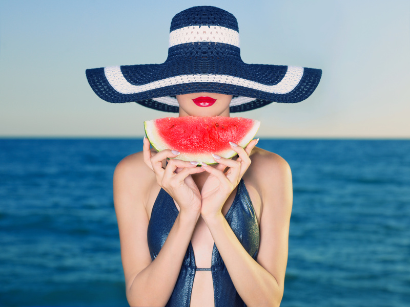 Jeune femme avec un chapeau et une pasthèque à la mer