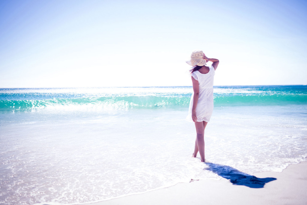 Belle jeune femme avec un chapeau au bord de la mer