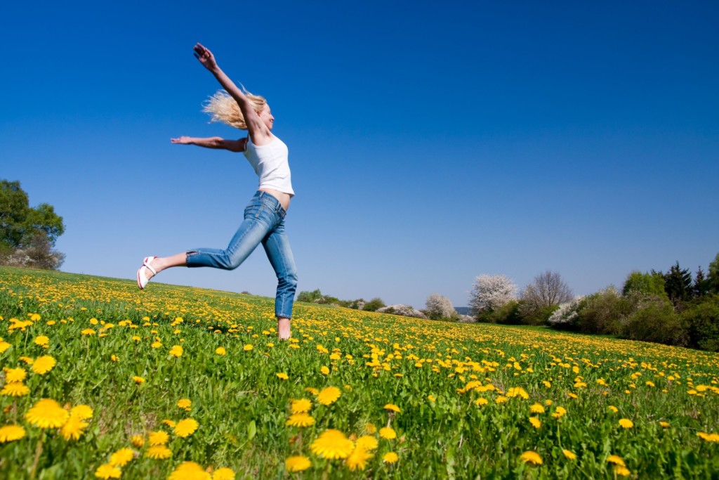 Jeune femme qui coure dans une prairie fleurie